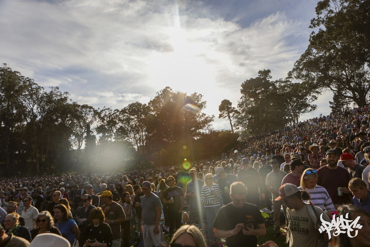 Sun flares over a huge crowd packed onto the hillside at Hardly Strictly Bluegrass 2026, Golden Gate Park. Photo by Michael Cruzada.