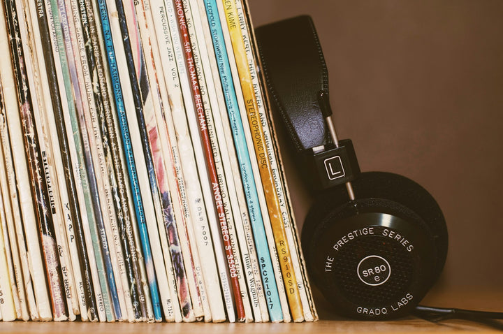 Black headphones resting against a row of vintage vinyl records. Photo by blocks on Unsplash (placeholder)