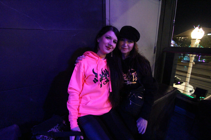 Two friends sitting together at The World of Drum and Bass, Zai Nightclub, Las Vegas, 2024