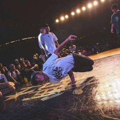 B-boy hitting a freeze on stage in front of a crowd