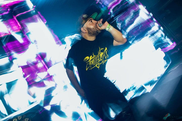 MC on the mic in front of bright visuals at The World of Drum and Bass, Kemistry, Fort Lauderdale