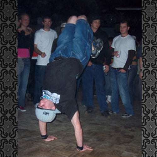 B-boy in a freeze in front of a crowd at a night session