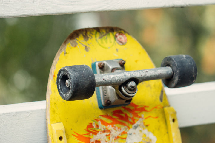 Dolores Park hill bomb lawsuit: an old skateboard with a yellow deck on a city street near a white fence (photo by Griffin W. via Pexels)