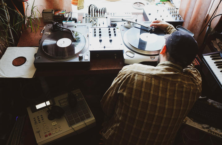 Beatmaker working on turntables and a sampler, seen from above