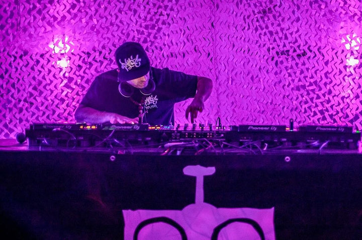 UK garage DJ FX Logik on the decks under purple lights, photo by Pistola Peeps