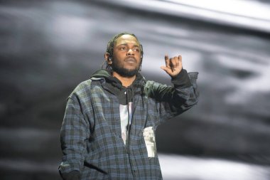 Kendrick Lamar on stage in a plaid shirt