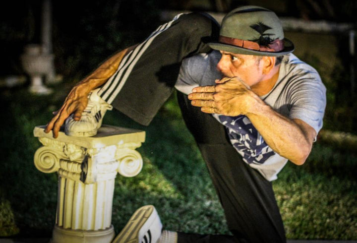 Popper Wave-O-Matic hitting a pose next to a stone column at night